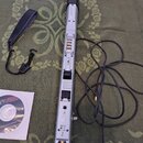 Stříbrný elektronický dechový nástroj z plastu a kovu s černými prvky. Na spodní části je vidět nápis FC CE a symboly pro napájení a USB. Součástí je…