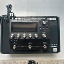 Černý kytarový procesor s nápisy BOSS GT-1000CORE GUITAR EFFECTS PROCESSOR a logo BOSS. Zařízení má displej, pět stříbrných oválových tlačítek, někol…