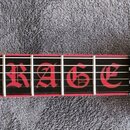 Detail krku a hlavy elektrické kytary v černé barvě s červenými detaily. Na hmatníku je červený nápis „RAGE“ a symbol lebky s kříženými meči. Na hlav…