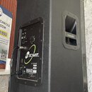 Černý aktivní reproduktor v plastovém korpusu s texturovaným povrchem, umístěný na stojanu. Na boku je vidět logo kxaudio a na zadním panelu nápis KX…