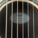 Detail zněku akustické kytary s viditelným vnitřním štítkem. Na štítku je logo Cort GUITARS, nápis MODEL: A PF BEVEL NAT a SERIAL NO: A250902433, v d…