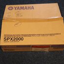 Kartonová krabice hnědé barvy s nápisy. Na horní části a spodním okraji je logo a název YAMAHA, uprostřed je uveden model SPX2000 a text PROFESSIONAL…