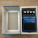 Modrý efekt pedál značky BOSS, model Compression Sustainer CS-3, umístěný v bílé papírové krabici. Na horní části jsou čtyři ovládací knoflíky s popi…