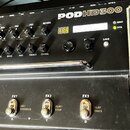Černý kytarový procesor s nápisem PODHD300 a logem LINE 6 na pravé straně. Zařízení obsahuje řadu ovládacích knoflíků, přepínačů a digitální displej.…