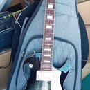 Elektrická kytara typu Les Paul s tmavě modrým průhledným lakem a viditnou strukturou dřeva. Na hlavě je bílé logo Cort, na hmatníku jsou bílé blokov…