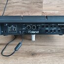 Zadní strana černého elektronického nástroje značky Roland. Jsou zde vidět různé konektory s popisky: 10-SPEED USB (MEMORY, COMPUTER), DC IN, MIDI (O…