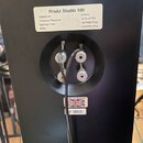 Zadní strana černého reproduktoru s bílým štítkem, na kterém je nápis ProAc Studio 100 a technické specifikace: Impedence 8 ohms, Frequency Response…