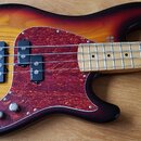 Elektrická basová kytara s tělem v barvě sunburst a javorovým hmatníkem. Nástroj má červený perleťový pickguard a dva snímače, na kterých je viditeln…
