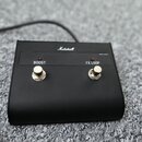 Černý efektový pedál s logem Marshall na horní hraně. Na předním panelu jsou dva stomečové spínače s nápisy BOOST a FX LOOP, nad nimi se nacházejí dv…