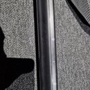 Detailní záběr na černý, hladký kovový tubus s vertikální drážkou. Podél drážky jsou v pravidelných rozestupech umístěna malá bílá čísla 1, 2, 4 a 5.…