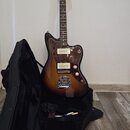 Elektrická kytara s trupem v barevném přechodu od žluté po tmavě hnědou a hnědým hmatníkem. Na hlavě je viditelné logo Fender. Kytara má tmavě hnědý…