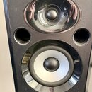 Černý studiový monitor s lesklým povrchem. Na spodní hraně je bílý nápis ALESIS a pravděpodobně ovládací prvek s nečitelným popiskem. V horní části j…