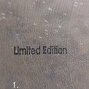 Detailní záběr na tmavý dřevěný povrch. Uprostřed je černý nápis Limited Edition. Povrch vykazuje drobné škrábance a opotřebení.