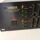 Černý grafický ekvalizér s nápisy YAMAHA, GRAPHIC EQUALIZER a MODEL Q2031A. Zařízení má zapínací tlačítko s označením POWER ON/OFF a řadu posuvníků s…