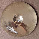 Kruhový mosazný činel s vyvýšeným středem. Na povrchu je bílý nápis Zildjian. Povrch činelu vykazuje v dolní části kování a drobné nečistoty. Na spod…
