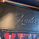 Černý tvrdý kufýr s texturovaným povrchem. Uprostřed víka je vyražené logo Fender® a pod ním v obdélníku nápis USA. Povrch vykazuje drobné oděrky a z…