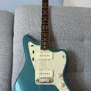 Modrá elektrická kytara s bílým pickguardem a hnědým hmatníkem. Na hlavě je viditelné logo Fender. Kytara má jeden snímač typu humbucker u kobylky a…