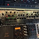 Fotografie zachycuje modulární syntetizátor v modrém case. Jsou zde vidět moduly značky behringer s nápisy VOCODER VC16, CHAOS, SKIES a WAVES v horní…