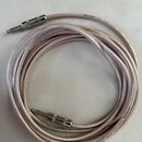 Stříbrný pletený instrumentální kabel s dvěma 6,3mm jack konektory. Konektory mají kovové stínění s drážkovaným povrchem. Na kabelu jsou viditelné ne…