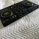Černý DJ kontrolér s dvěma jog-koly a centrálním mixážním sekcí. Na pravé straně je viditelný nápis Pioneer DJ a označení modelu DDJ-400. Povrch přís…