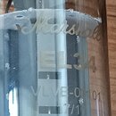 Detail skleněné elektronky s nápisy. Na povrchu je vidět logo Marshall, označení modelu EL34 a kód VLVE-01101 následovaný zlomkem 17/1. Povrch skla v…
