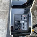 Detailní pohled na černý preamp zabudovaný v těle kytary. Na zařízení je bílým nápisem logo Takamine a označení modelu CT-4BII. Ovládání tvoří čtyři…