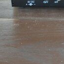 Detail zadní strany černého elektronického zařízení s nápisy MX 510 a částí loga v horní části. Jsou zde vidět konektory s popisky power (9V DC), amp…