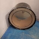 Černý basový buben s napnutými bílými koženými membránami. Na přední membráně je logo REMO a nápisy WEATHERKING, FIBERTONE, MADE IN U.S.A. Povrch bub…