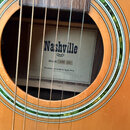 Detail zněku akustické kytary s viditelným štítkem uvnitř korpusu. Na štítku je uveden název Nashville, model NW-34 a nápis Vyrobeno pro Andiana Musi…
