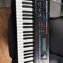 Černý digitální klávesový nástroj s bílými a černými klávesami. Na ovládacím panelu jsou viditelné nápisy D BEAM, VOLUME, MODE/MIC a KEYBOARD. Jsou z…
