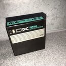 Černá plastová datová kazeta s nápisy YAMAHA DATA CARTRIDGE a DX. Na horní straně je tyrkysový štítek s textem VOICE ROM a DX7. V levé části je přepí…