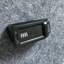 Černý plastový přístroj s USB portem. Na boku je nápis INPUT 5V 2A a symbol USB, vprostřed jsou čtyři kontrolní LED diody. Na pravém okraji je vidite…