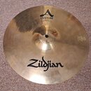 Zlatý mosazný činel s viditelným broušením. Na povrchu jsou nápisy „A CUSTOM“, „HIHAT BOTTOM 14"/36 cm“ a velké logo „Zildjian“. V pravé části je vyr…