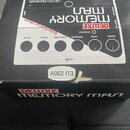Fotografie znázorňuje kartonovou krabici s efektem Memory Man. Na horní části je zobrazen nápis electro-harmonix a model DELUXE MEMORY MAN. Jsou zde…