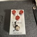 Kovový efekt pedál stříbrné barvy s třemi červenými oválnými knoflíky. Na horní části jsou nápisy MADE IN USA, 9VDC, GAIN, OUTPUT a TREBLE. Uprostřed…