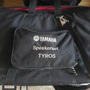 Černá textilní přepravní taška s rukojetmi a ramenním popruhem. Na přední kapse je bílý nápis s logem YAMAHA, pod ním text Speakerset a dále TYROS. P…
