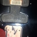 Detail zadní strany černé elektrokitary s vybranými kryty elektroniky. V horním výřezu je nalepený štítek s čárovým kódem a označením MO2759174. Spod…