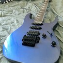 Modře lakovaná elektrická kytara s dvojcutem a černým hardwarem. Nástroj má dva humbuckery, Floyd Rose tremolo systém a dva ovládací knofíky s nápisy…