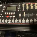 Černý sampler s nápisy Elektron a OCTATRACK. Na horní části je text DYNAMIC PERFORMANCE SAMPLER, displej a několik ovládacích prvků včetně bílých oto…