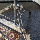 Detail spodní části chromovaného stativu s trojnožkou. Povrch vykazuje známky opotřebení v podobě drobných škrábanců a oxidace. Na fotce nejsou žádné…