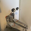 Dvojpedál na buben z kovového materiálu stříbrné barvy s oranžovými detaily. Na obou pedálech je v pravé dolní části nápis Pearl a na šlapkách jsou o…
