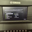 Detailní pohled na horní část černého digitálního klavíru značky YAMAHA. Uprostřed je umístěn displej s otevřeným menu Registration Memory, kde jsou…