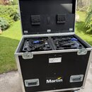 Černý transportní flightcase na kolečkách s hliníkovými hranami a vrchním víkem. Uvnitř jsou umístěna dvě černá svítidla s připojenými kabely a konek…