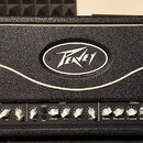 Černý kytarový zesilovač s texturovaným povrchem a bílým ozdobným lemováním. Na předním panelu je oválné logo Peavey a nápis ValveKing®100. Ovládací…