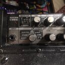 Horní ovládací panel černého kytarového komba s nápisy MICRO CUBE a COSM AMPLIFIER. Panel obsahuje několik otočných ovladačů označených jako TONE, EF…
