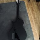 Černá elektrická kytara s trupem ve tvaru singlecut. Na hlavě hmatníku jsou vidět stříbrné ladičky a nápis "Epiphone". Povrch nástroje je vysoce lesk…