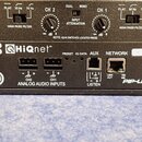 Detail zadního panelu černého elektronického zařízení. Na panelu jsou nápisy HiQnet, PIP2, IQ3, TCP / IQ a PIP-LITE. Jsou zde vidět dva symetrické vs…