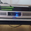 Hliníkový transportní case obsahuje dvě rackové jednotky. Horní zařízení je černé s nápisy AMERICAN AUDIO a DB DISPLAY MKII, vybaveno řadou zelených…