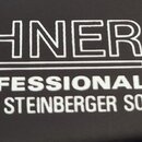 Detailní záběr na černý povrch s bílými nápisy. Je zde vidět logo HOHNER, pod kterým je napsáno PROFESSIONAL a LICENSED BY STEINBERGER SOUND. Vedle t…