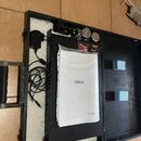 Otevřený černý kufřík s bílou vnitřní výplní, ve kterém je umístěno černé zařízení a dokumentace v plastovém obalu s nápisem YAMAHA. K zařízení je př…